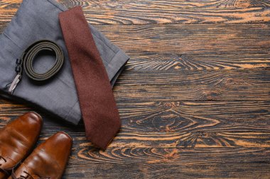 Ahşap arka planda şık erkek kıyafetleri ve aksesuarlar.