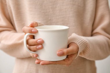 Bir fincan sıcak çay içen kadın, yakın plan.