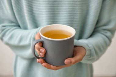 Bir fincan sıcak çay içen kadın, yakın plan.