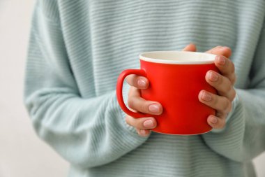 Bir fincan sıcak çay içen kadın, yakın plan.