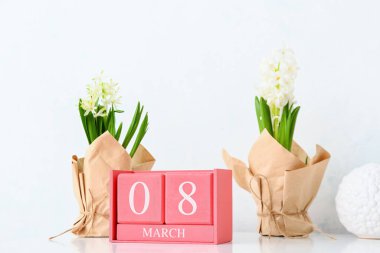 8 Mart tarihli küp takvimi ve masada çiçekler. Uluslararası Kadınlar Günü kutlamaları