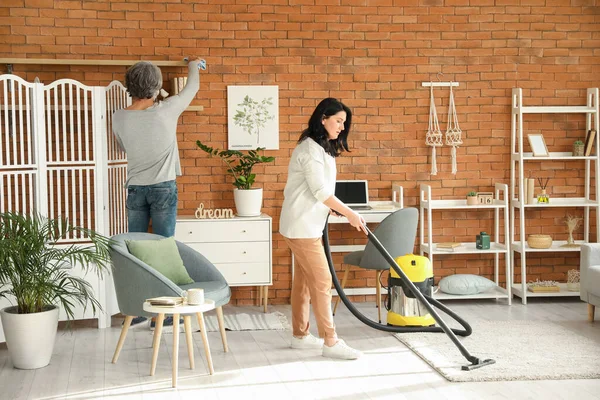 Mature Woman Hoovering Carpet Home — Stock Photo, Image