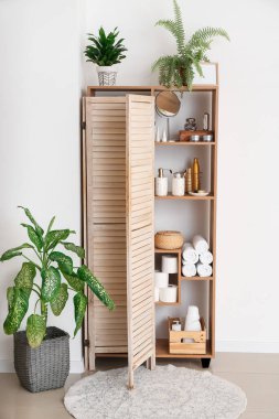 Modern raf ünitesi ve banyo aksesuarları olan bir banyo.