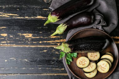 Koyu ahşap arka planda taze patlıcanları olan kompozisyon