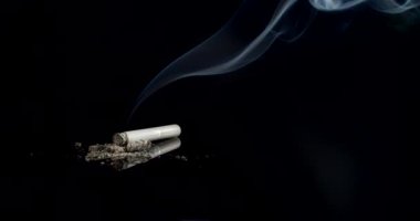 Esmer arka planda dumanlı sigara.