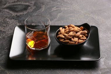 Bir bardak badem likörü ve koyu fındıklı tepsi.