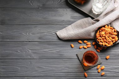 Bir bardak badem likörü ve koyu ahşap arka planda fındık.