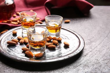 Bir bardak badem likörü ve koyu fındıklı tepsi.