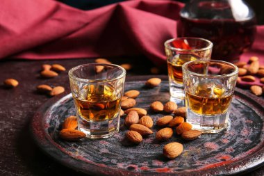 Bir bardak badem likörü ve koyu fındıklı tepsi.