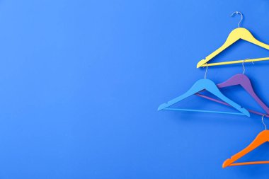 Renkli arkaplanda farklı elbise askıları