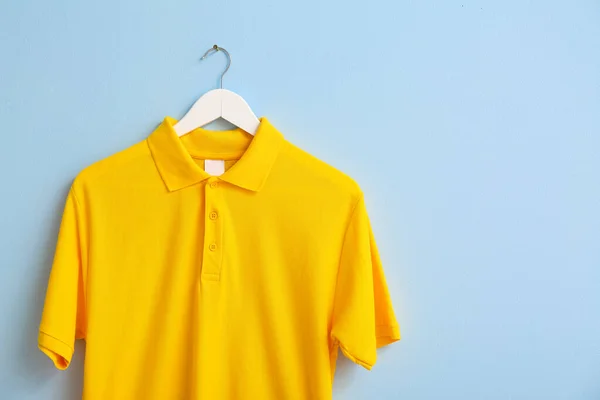 Stylish shirt hanging on color background