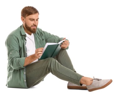 Genç adam beyaz arka plan üzerine kitap okuyor.