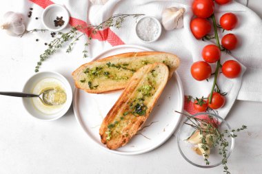 Hafif arka planda kızarmış ekmek, sarımsak ve domatesli kompozisyon