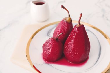 Kaynamış armut ve kırmızı şarap tabağı.