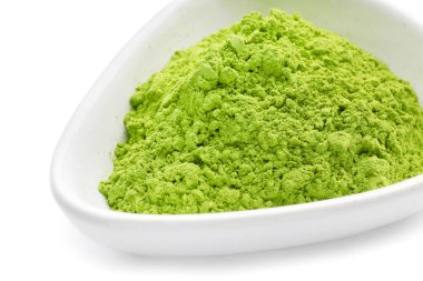 Beyaz arka planda pudralanmış kibrit çayı ile kase