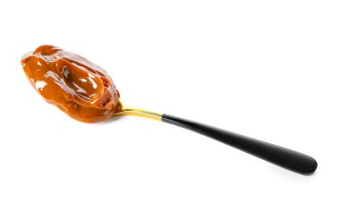 Beyaz arkaplanda kaynamış yoğunlaştırılmış süt kaşığı