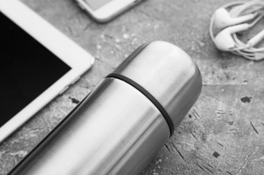 Grunge arka planında cihazları olan modern termos, yakın plan.