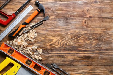 Marangoz aletleri seti ve ahşap arka planda toz gördüm.