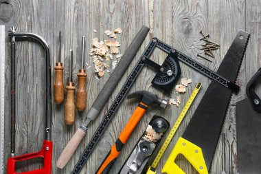 Marangoz aletleri seti ve ahşap arka planda toz gördüm.