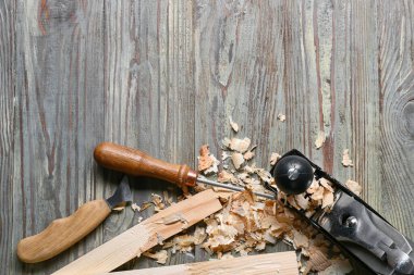 Marangoz aletleri seti ve ahşap arka planda toz gördüm.