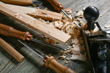 Marangoz aletleri seti ve ahşap arka planda toz gördüm.