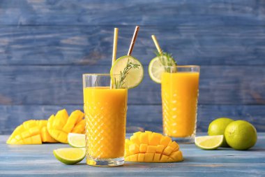 Renkli ahşap arka planda bir bardak lezzetli mango kokteyli.