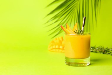 Renkli arkaplanda bir bardak lezzetli mango kokteyli.