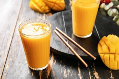 Koyu ahşap arka planda lezzetli mango kokteylleri.