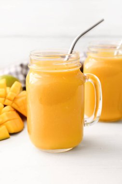 Mason kavanozları hafif arka planda lezzetli mango smoothie