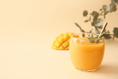 Renkli arkaplanda bir bardak lezzetli mango kokteyli.