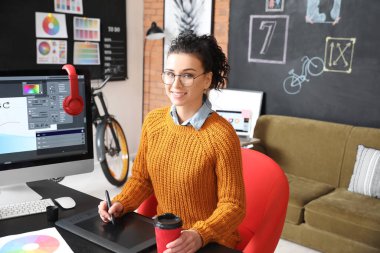 Genç bayan tasarımcı ofiste çalışıyor.