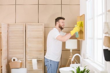 Genç adam banyoyu temizliyor.