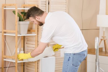 Genç adam banyoyu temizliyor.