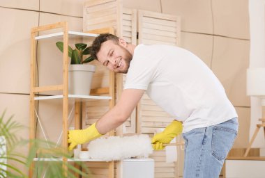 Genç adam banyoyu temizliyor.