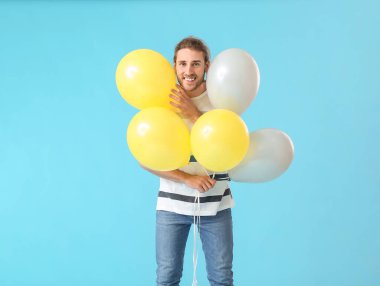 Renkli balonları olan yakışıklı bir genç.