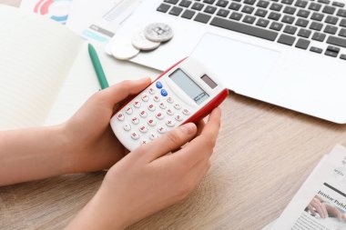 Hesap makinesi olan kadın masadaki harcamaları sayıyor