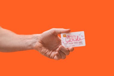 Renk arkaplanında hediye kartı olan el