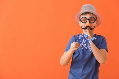 Kağıt balıklı küçük çocuk arka planda sessizlik jesti yapıyor. 1 Nisan şakası