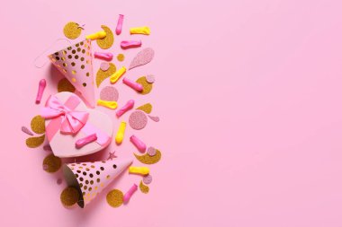 Parti şapkaları ve renk arkaplanı hediyeli şenlikli kompozisyon