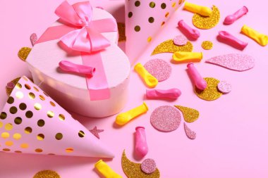 Parti şapkaları ve renk arkaplanı hediyeli şenlikli kompozisyon