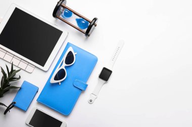 Modern akıllı saat, tablet bilgisayar, cep telefonu ve arka planda kum saati