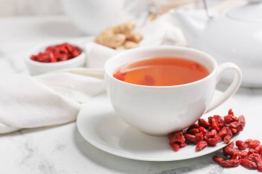 Hafif arkaplanda goji çayı olan bir fincan.