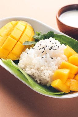 Renkli arka planda lezzetli pirinç ve mangolu tabak, yakın plan.