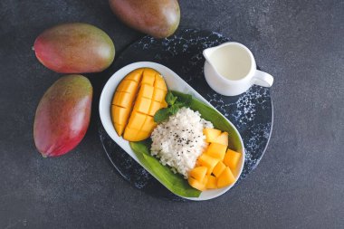 Koyu arkaplanda lezzetli pirinç ve mango tabağı