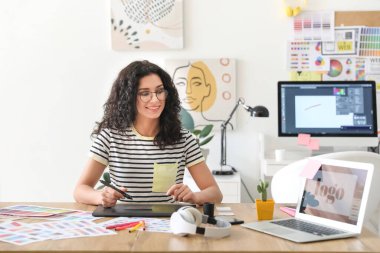 Genç bayan tasarımcı ofiste çalışıyor.