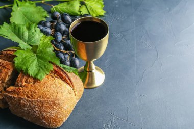 Koyu arkaplanda şarap ve ekmek kadehi