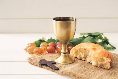 Şarap kadehi ekmek ve haç beyaz ahşap arka planda