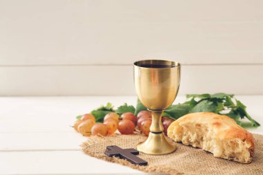 Şarap kadehi ekmek ve haç beyaz ahşap arka planda