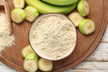 Ahşap zemin üzerinde muz unu olan bir kase