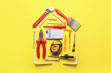 Renk arkaplanı üzerinde hesap makinesi ve inşaat araçları ile bileşim